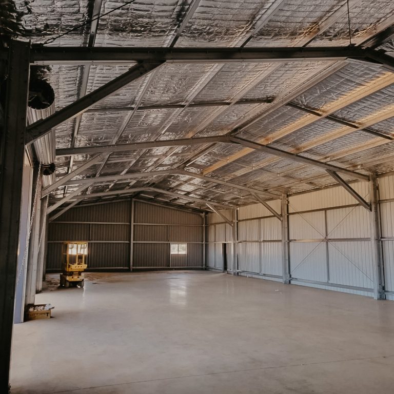Spacious empty shed interior with high ceiling.