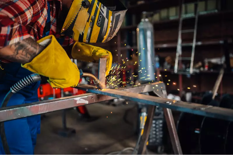 worker in a workshop welding a metal construction